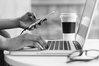 women using a phone and laptop